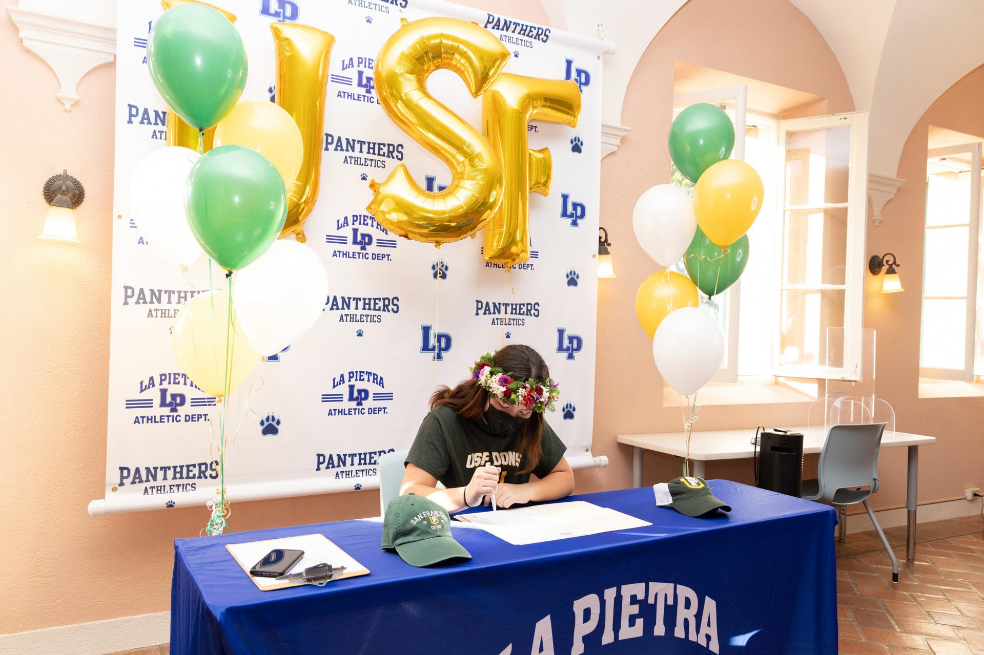 Chee signs her letter in front of friends and family