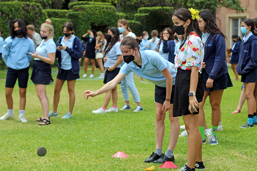 Junior Elsa G. (right) oversees students playing ulu maika.