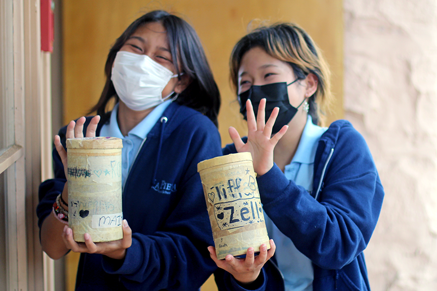 Mai A. and Chloe N. show off their pinhole cameras.