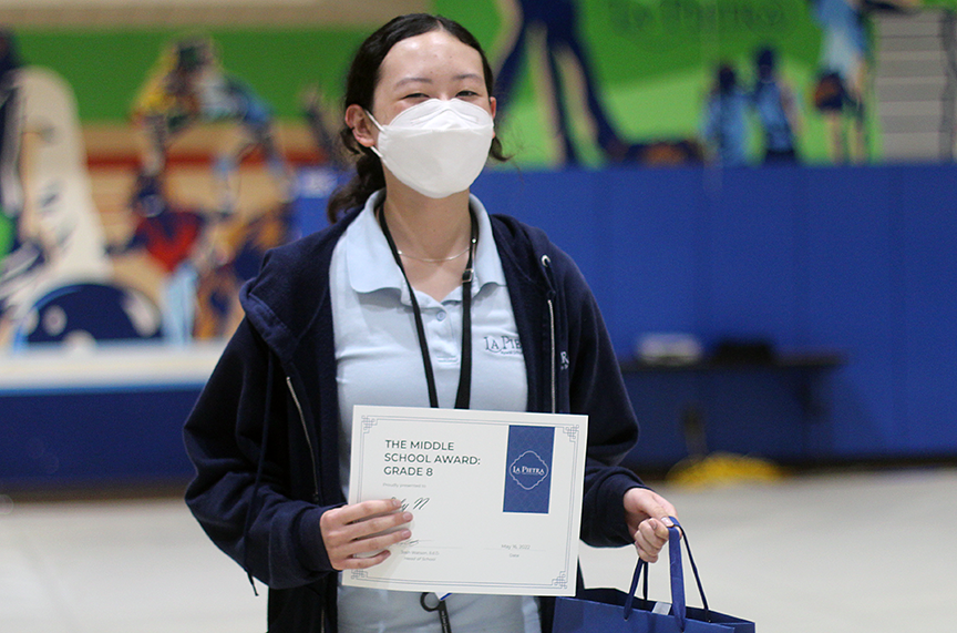 Lily N. poses with her certificate after receiving the Middle School Award for the 8th grade.