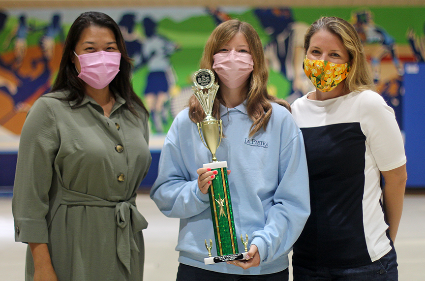 Hawaii State Spelling Bee Executive Director Jennifer Yang presents 7th grader Emma M. her trophy.