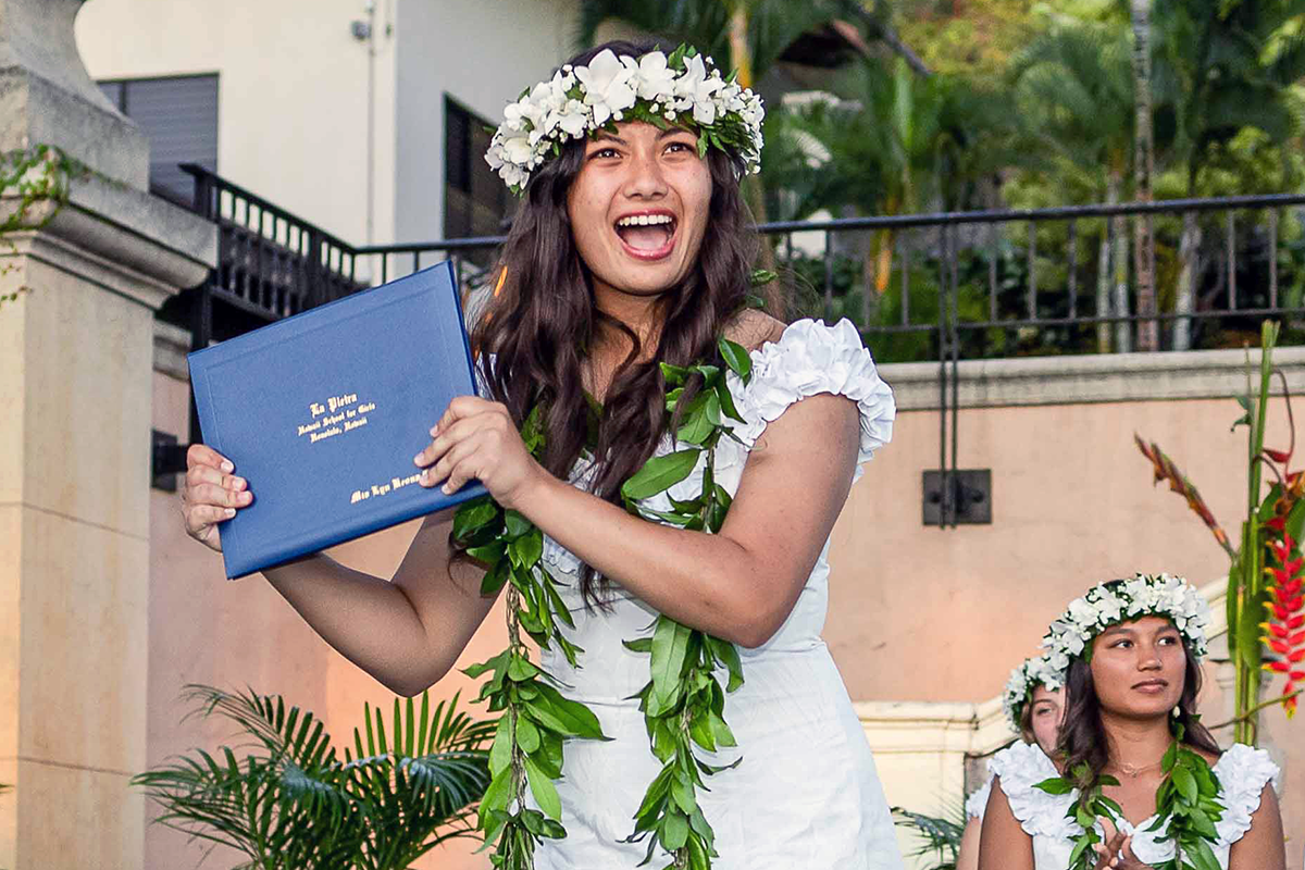 Mia C. celebrates with her diploma.