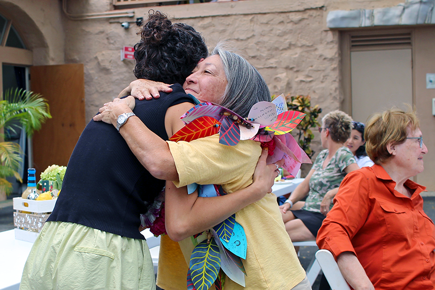 Art teacher Ms. Morgan Kelly presents Gay with a lei made up of messages from students.