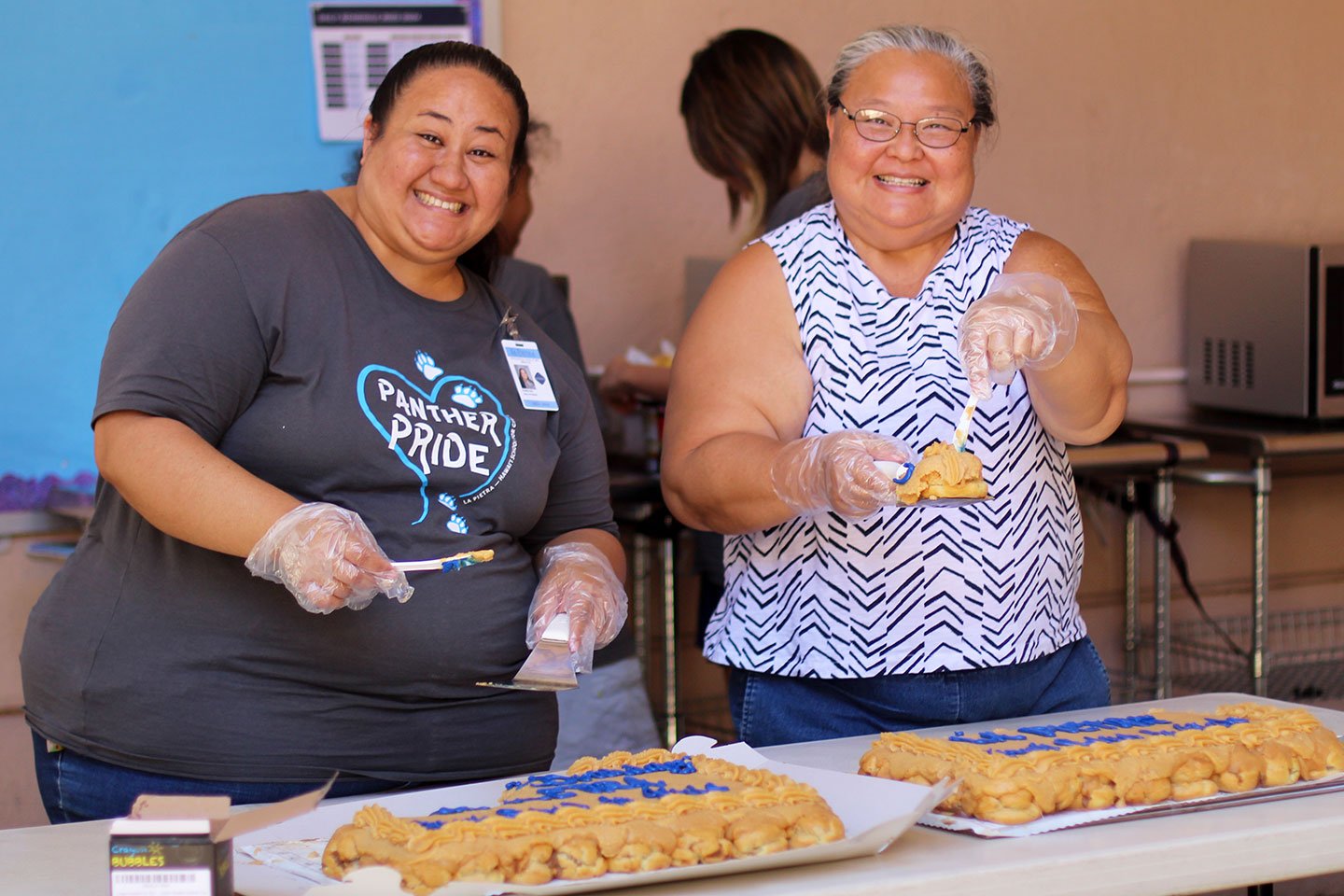 Dean of Students Kristie Han '00 and parent volunteer Mel Namiki Roberts serve up some Coco Puffs!