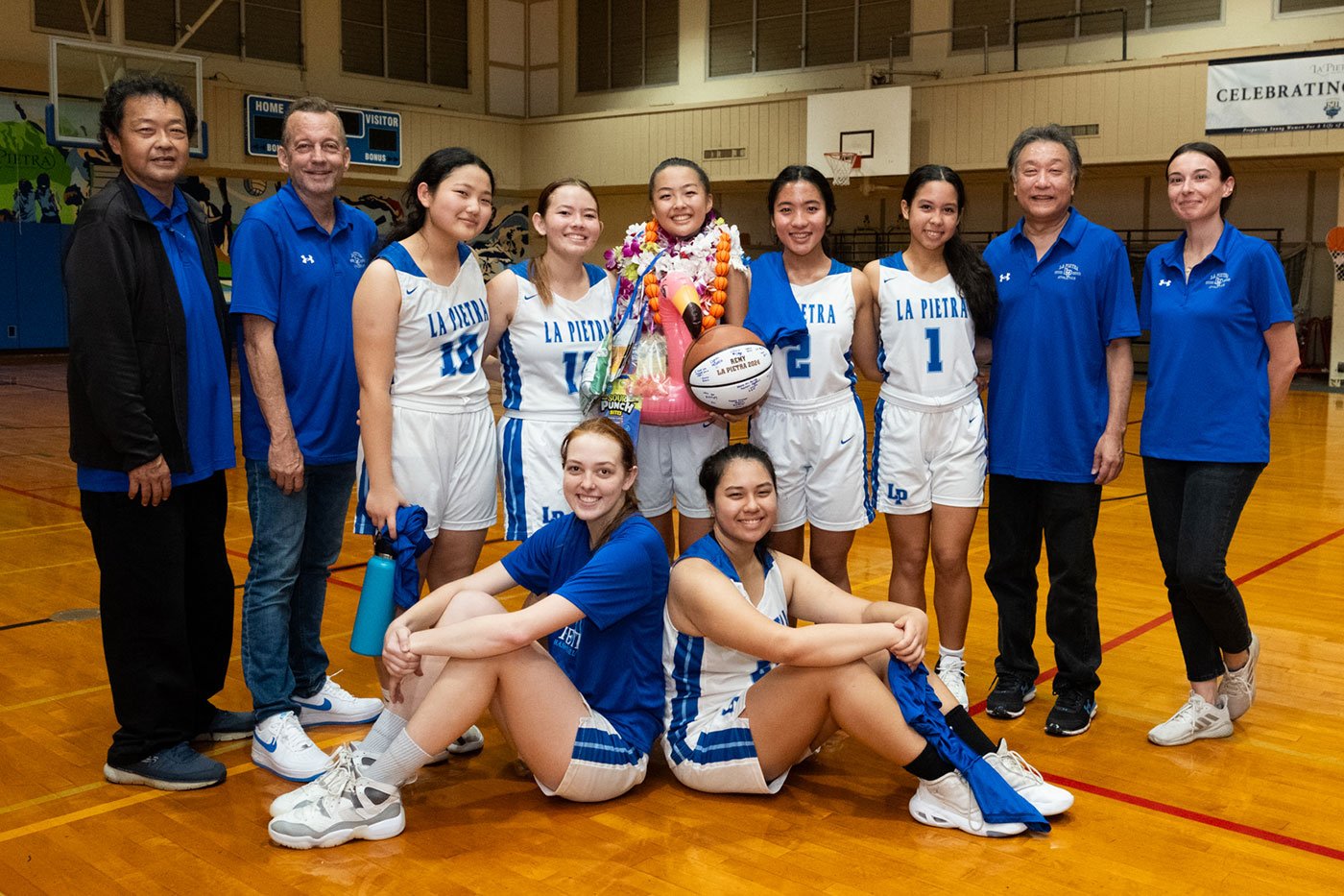 Senior Remy K. celebrates a victory with her varsity basketball teammates after the last home game of the season in 2024.